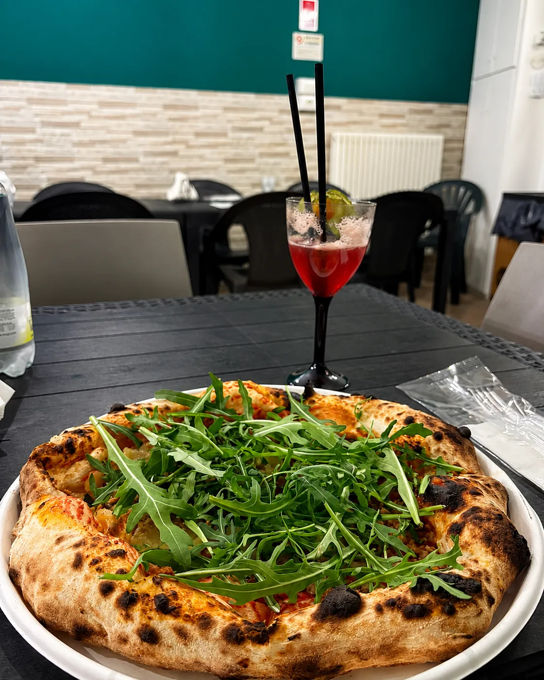 Pizza abbinata a un drink servito al tavolo